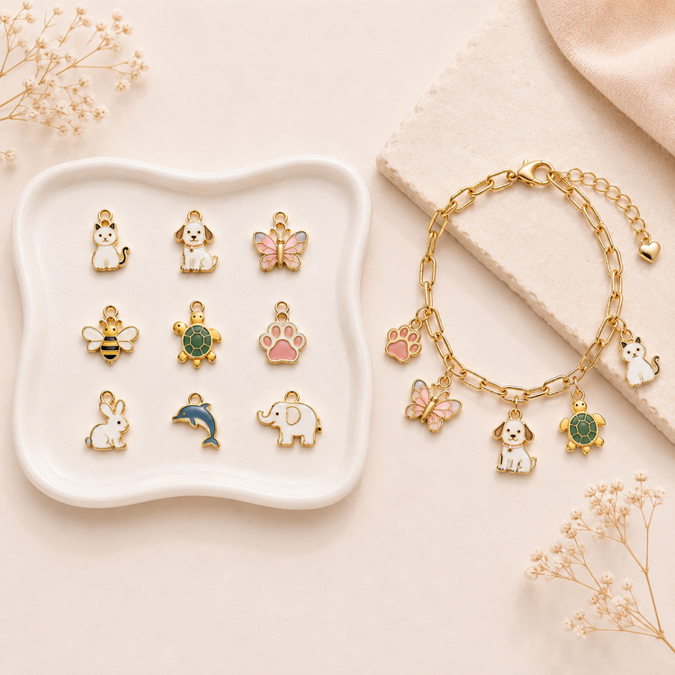 Animal charms for personalised jewellery UK with cat, dog, butterfly, bee, turtle and paw charms beside a gold charm bracelet