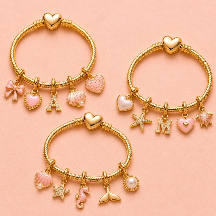 Gold charm bracelets with personalised heart, letter, shell, starfish and animal charms on a soft pink background