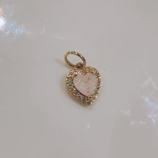 Blush pink heart charm with a sparkling crystal edge on a white background