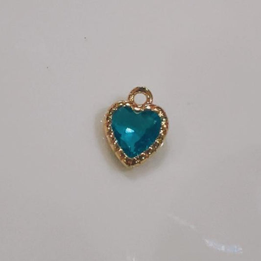 Bright teal heart charm with a sparkling crystal edge on a white background