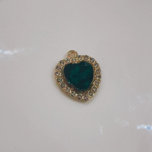 Green heart charm with a sparkling crystal edge on a white background