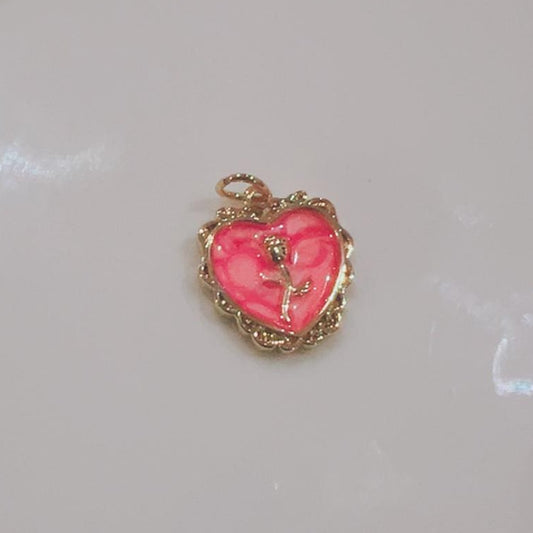 Pink rose heart charm with a gold-coloured rose and scalloped edge on a white background