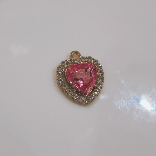 Rose pink heart charm with a sparkling crystal edge on a white background