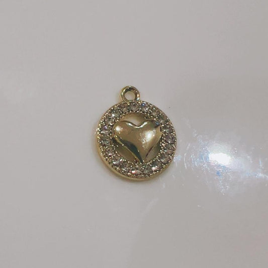 Round coin charm with a heart in the middle and a sparkling border on a white background