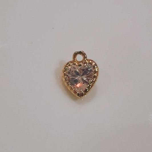 Small blush pink crystal heart charm on a white background