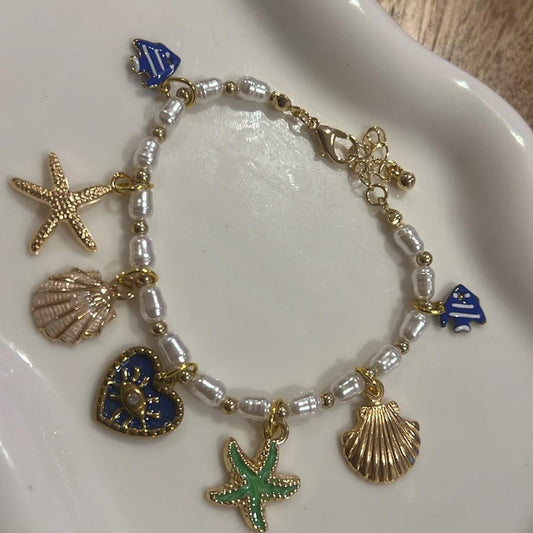 White beaded sea charm bracelet with starfish, shell and turtle charms
